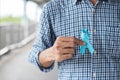 November Prostate Cancer Awareness month, Man in blue shirt with hand holding Blue Ribbon for supporting people living and illness