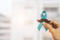 November Prostate Cancer Awareness month, Man holding Blue Ribbon with mustache for supporting people living and illness.