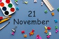 November 21st. Day 21 of last autumn month, calendar on blue background with school supplies. Business theme