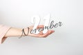 November 21st . Day 21 of month, Calendar date. Calendar Date floating over female hand on grey background. Autumn month, day of