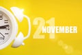 November 21st . Day 21 of month, Calendar date. White alarm clock on yellow background with calendar day. Autumn month, day of the