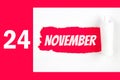 November 24th. Day 24 of month, Calendar date. Red Hole in the white paper with torn sides with calendar date. Autumn month, day