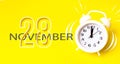 November 28th. Day 28 of month, Calendar date. White alarm clock with calendar day on yellow background. Minimalistic concept of