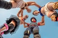 27 November 2016. Three smiling women and one serious clown standing on stilts in the circle in Leme, Rio de Janeiro, Brazil