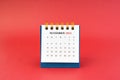 November 2024 white desk calendar on red background