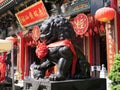 November 13, 2023. Wong Tai Sin Temple. Black color statue of lion dog in front of Wong Tai Sin temple\'s main building.