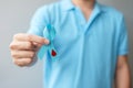 November World Diabetes day Awareness month, man holding light Blue Ribbon with blood drop shape for supporting people living,