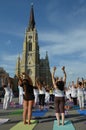People participate in a yoga event in the center of the city