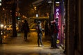 People, youngsters, waiting at night in front of a fast food restaurant catering facility to order food to take away in the street