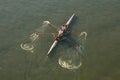 Two boys rowing, training, in a racing scull on a sunny day on river Danube in Novi Sad