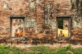 Novice monk reading books in ruins. Royalty Free Stock Photo