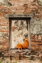 Novice monk reading books in ruins at Putthaisawan temple. Royalty Free Stock Photo