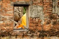 Novice monk reading books in ruins at Putthaisawan temple. Royalty Free Stock Photo