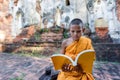 Novice monk reading outdoors