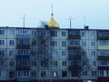 Novodvinsk - Arkhangelsk, Russia, April 2019. The dome of the Orthodox Church above the panel five-story building