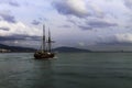 Sailboat `Atyla` leaves the bay in the sea against the backdrop of mountains at sunset. Royalty Free Stock Photo