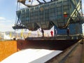 Wagon of the hopper for unloading on a cargo ship. Lifting operations in the port.