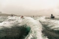 Jet ski watercraft drivers driving waterbikes in open Black Sea at storm