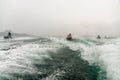 Jet ski watercraft drivers driving waterbikes in open Black Sea at storm