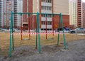 Children run on the street past swings on the Playground in the courtyard of an apartment building covered with striped tape close Royalty Free Stock Photo