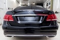 Close-up on a car Mercedes E-class body standing inthe garage box for polishing and removing scratches from the surface. Auto