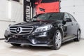 Close-up on a car Mercedes E-class body standing inthe garage box for polishing and removing scratches from the surface. Auto