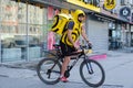 Novosibirsk, Russia-30.04.2020: a fast food delivery courier dressed in a yellow uniform delivers it on a bicycle