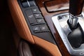 The interior of the car with a view of the seat heater and ventilation buttons, dashboard with light brown leather trim