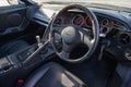 Interior of a rare Japanese sports car in the back of a gray Toyota Supra coupe with a dashboard, steering wheel, panel cockpit