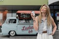 Novosibirsk, Russia - July 20, 2020: A hippie woman drinks coffee on the background of a camper. Classic Volkswagen van