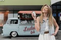 Novosibirsk, Russia - July 20, 2020: A hippie woman drinks coffee on the background of a camper. Classic Volkswagen van