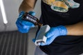 The process of applying a nano-ceramic coating Ceramic Pro 9h and Light on the sponge by a male worker with a chemical composition