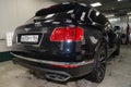 Rear view of luxury very expensive new black Bentley Bentayga car stands in the washing box waiting for repair in auto service