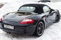 Rear view of the 2006 sports porsche boxster s coupe roadster prepared for sale with a polished shiny black body on snow winter at