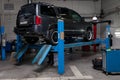 Used gray car Infiniti QX56 stands on the stand wheel alignment convergence of the car in the workshop for repair of vehicles Auto Royalty Free Stock Photo