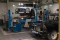 White used car Nissan Patrol raised on a blue lift for repairing the chassis and engine in a vehicle repair shop. Auto service