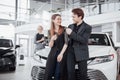 Now her dream comes true. Car salesman giving the key of the new car to the young attractive owners Royalty Free Stock Photo