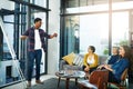 Now heres where it gets really interesting. a creative businessman giving a presentation to his colleagues in the office Royalty Free Stock Photo