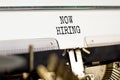 Now hiring symbol. Concept words Now hiring typed on beautiful old retro typewriter. Beautiful white paper background. Business
