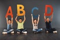 Now I know my ABC. Studio portrait of a diverse group of kids holding up letters of the alphabet against a gray Royalty Free Stock Photo