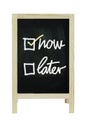 Now or Later with checkboxes - white chalk handwriting on blackboard Clipping path.