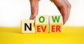 Now or never symbol. Businessman turns wooden cubes and changes the concept word Never to Nowa. Beautiful yellow table white Royalty Free Stock Photo