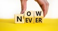 Now or never symbol. Businessman turns wooden cubes and changes the concept word Never to Nowa. Beautiful yellow table white