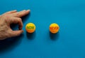 Now or never symbol. Male hand is about to flick the ball. Orange table tennis balls with words now never. Beautiful blue