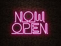 Now Open neon pink sign. Concept of recently opened business. Old weathered brick background, rustic look Royalty Free Stock Photo
