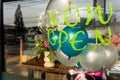 `Now Open` sticker on transparent balloon with other small colourful balloons inside.