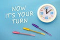 NOW IT`S YOUR TURN - lettering on a blue background and clock Royalty Free Stock Photo