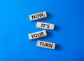 Now it is your turn symbol. Concept words Now it is your turn on wooden blocks. Beautiful blue background. Business and Now Royalty Free Stock Photo