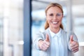 Now thats what Im talking about. Portrait of a mature businesswoman showing thumbs up in a modern office.