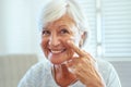 Now is the time to look after your skin. Portrait of a happy senior woman applying skin cream to her face at home. Royalty Free Stock Photo